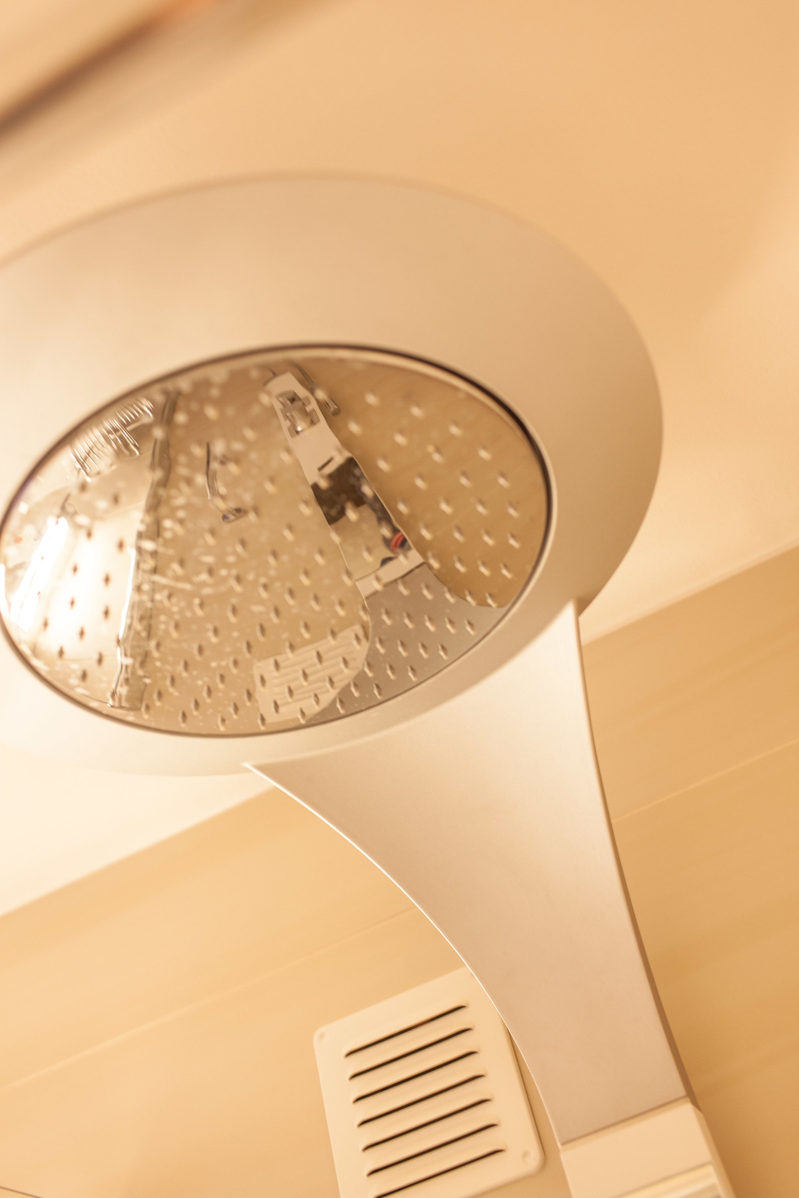 Ein an der Decke befestigter Rauchmelder mit kreisförmigem Design und Lüftungsgitter.