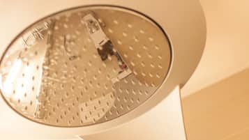 Ein an der Decke befestigter Rauchmelder mit kreisförmigem Design und Lüftungsgitter.