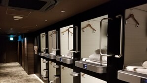 A hotel bathroom with multiple sinks, mirrors, and individual stalls. - Glansit Akihabara Comfort Capsule Hotel (Tokyo)