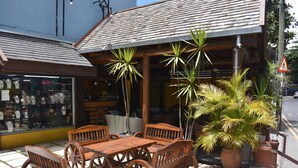 An outdoor seating area with wooden furniture and potted plants. - Ocean Lake Tourist Residence (Grand-Baie)