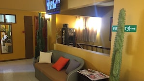 A lobby with a sofa, a cactus, a television, and a sign indicating the first floor. - Ocean Lake Tourist Residence (Grand-Baie)