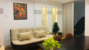 Un salon moderne avec un canapé, une table à manger et un escalier.