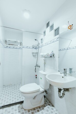 A bathroom with a toilet, sink, and shower. - Urban House Saigon 2 (Ho Chi Minh City)