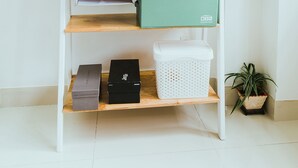 A white wall with a wooden shelf unit against it. - Urban House Saigon 2 (Ho Chi Minh City)