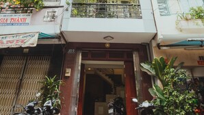 A multi-story building with balconies, potted plants, and parked motorcycles. - Urban House Saigon 2 (Ho Chi Minh City)
