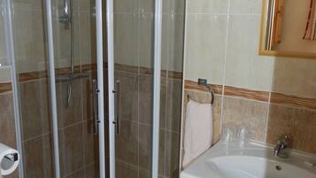 A bathroom with a glass-enclosed shower, a sink, and a toilet.