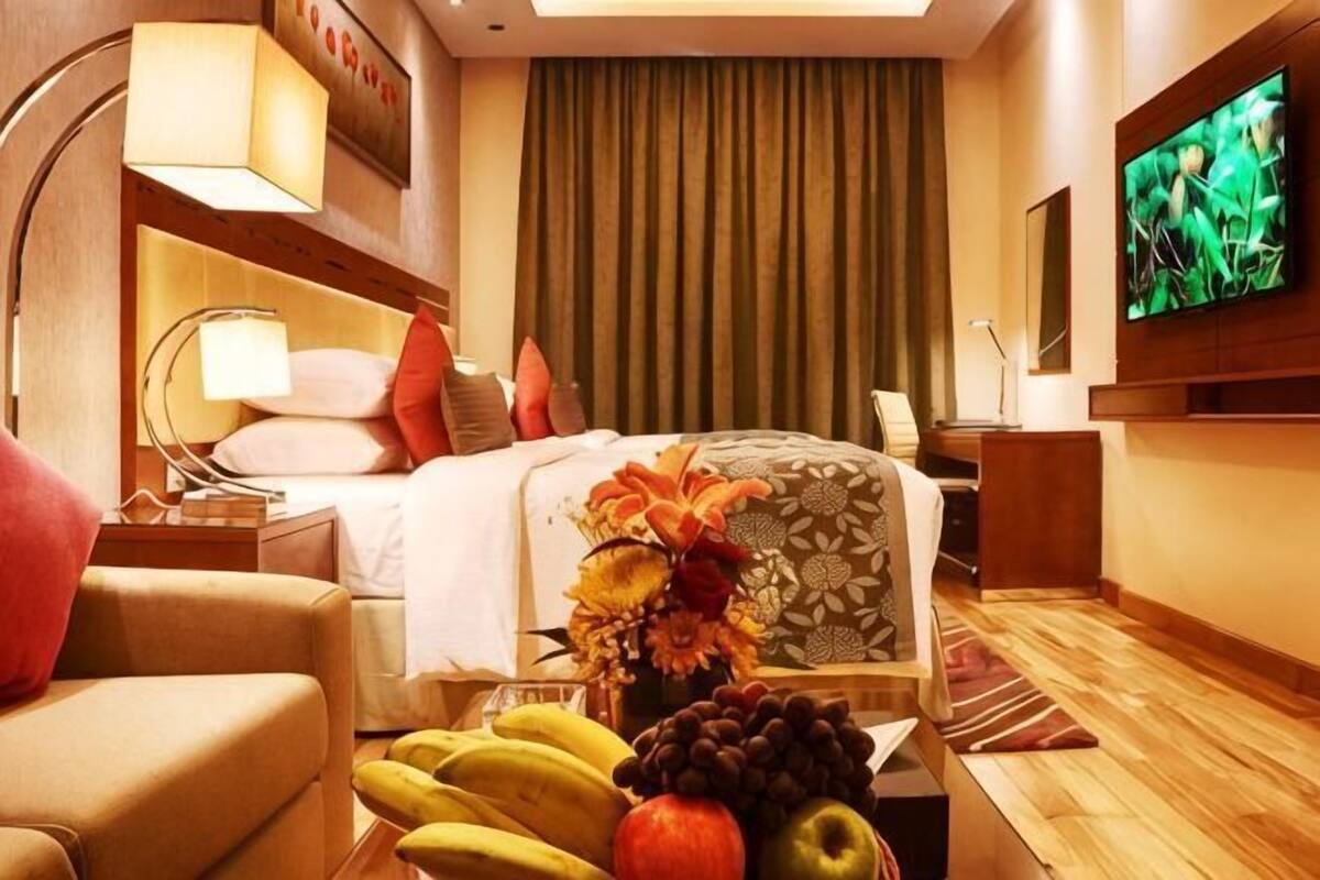 Ein Hotelzimmer mit einem Bett, einem Fernseher, einem Schreibtisch und einem Sessel.