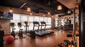 Een sportschool met loopbanden, elliptische trainers en gewichthefapparatuur.