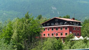A hotel with multiple floors, balconies, and a red and black facade.