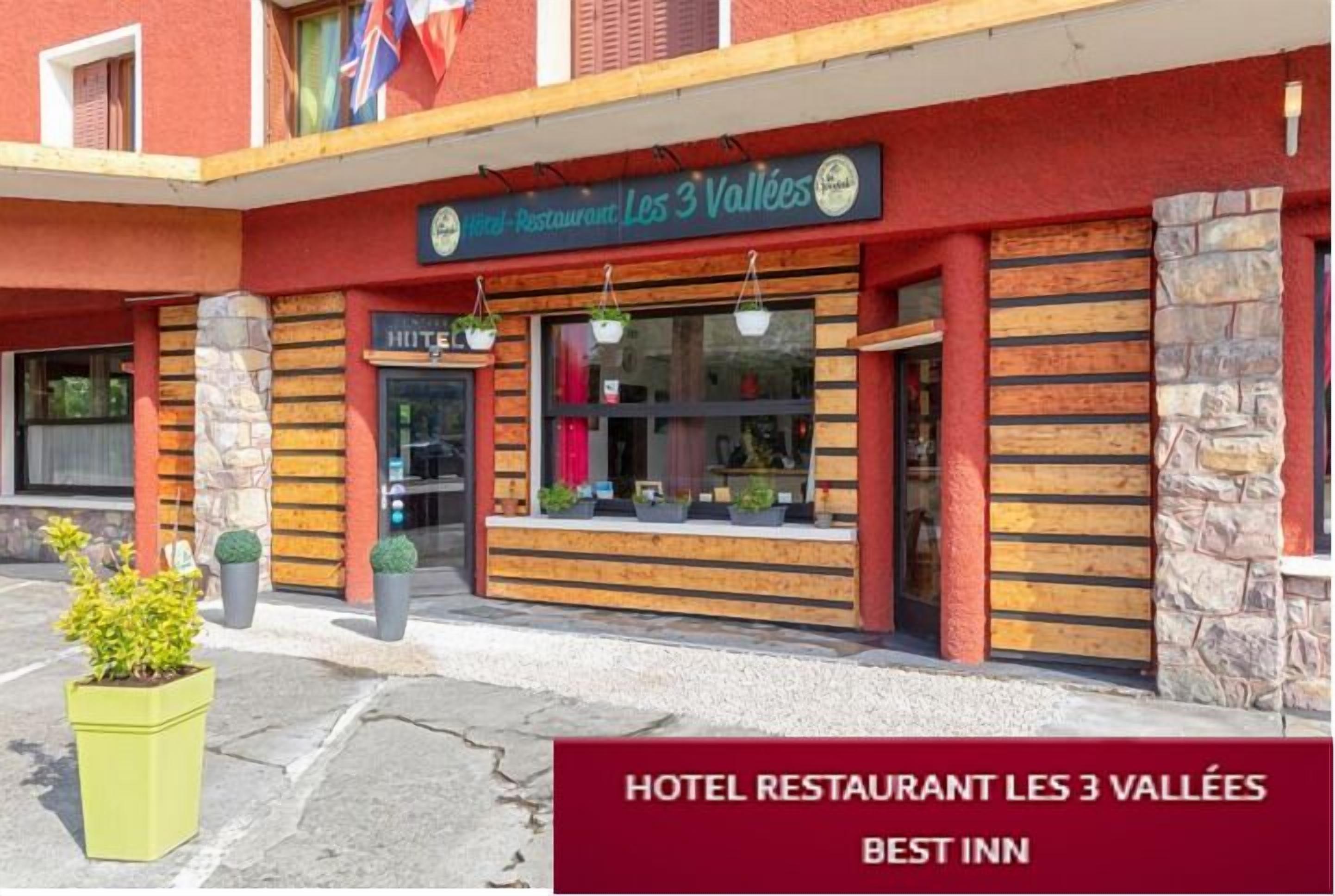 A hotel with a sign reading "Hotel Restaurant Les 3 Vallées."