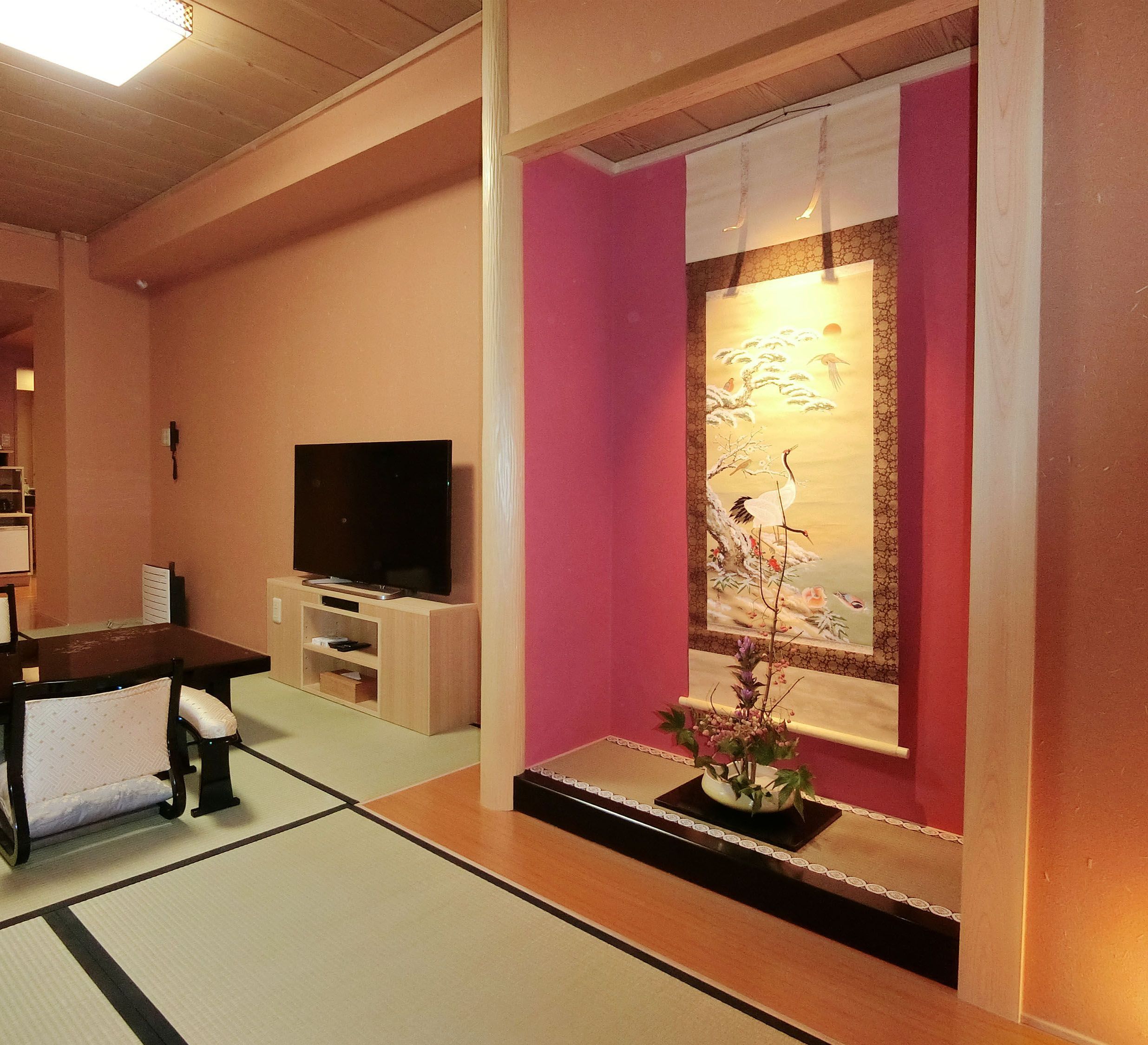 Una sala de estar con televisor, una mesita y un adorno en la pared.