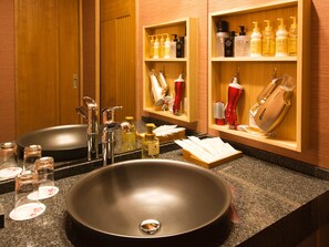 A bathroom with a large sink, two mirrors, and shelves with toiletries.