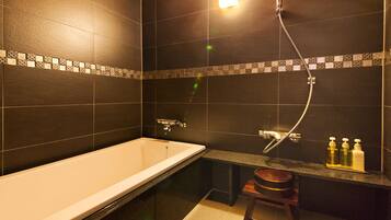 A modern bathroom with a bathtub, a shower, and a vanity with toiletries.