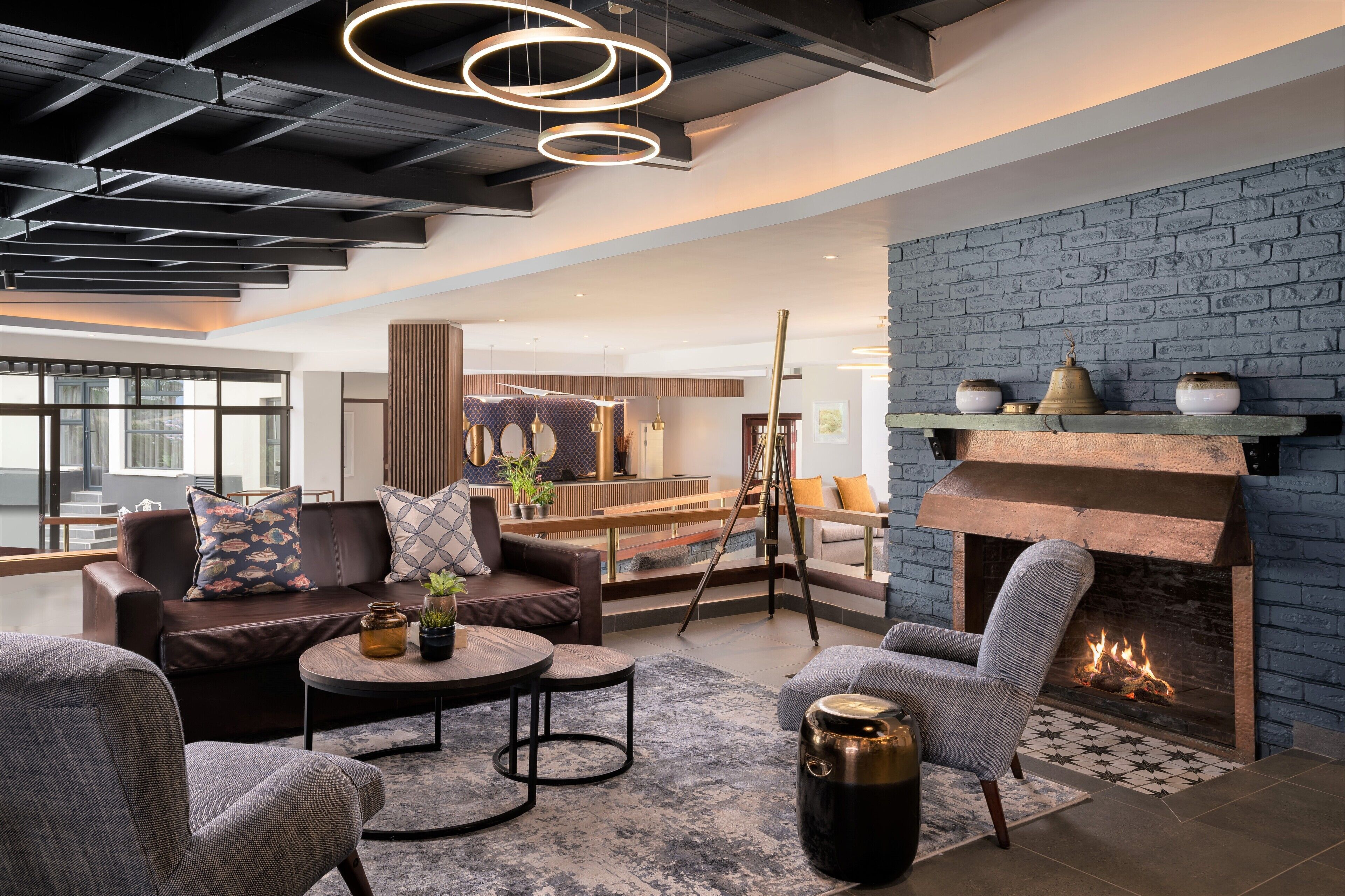 A modern living room with a fireplace, leather sofas, and a coffee table.