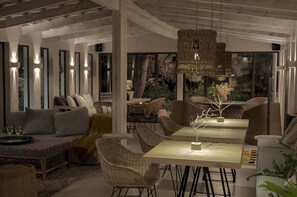 A modern interior with a dining area, sofas, and wicker chairs. - IridaChic Boutique Hotel & Spa (Hersonissos)