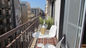 A balcony with a table, two chairs, a bottle of champagne, and a glass of wine. - Room 56 (Bari)