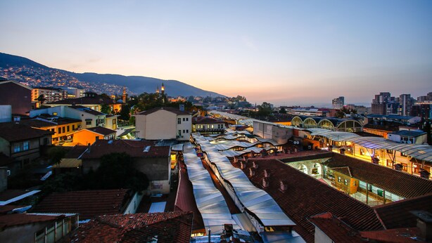 A cityscape at dusk with a prominent train station and surrounding buildings. - Kutlucan Oldtown Hotel (Bursa)