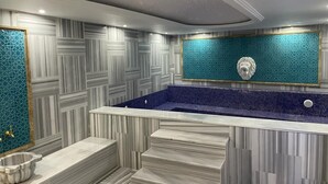 A modern bathroom with a marble vanity, a freestanding bathtub, and a decorative wall with a geometric pattern. - Kutlucan Oldtown Hotel (Bursa)