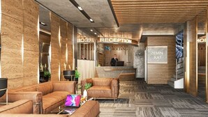 A modern reception area with a reception desk, leather sofas, and a wooden wall design. - Kutlucan Oldtown Hotel (Bursa)