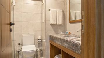 A modern bathroom with a toilet, sink, and mirror.