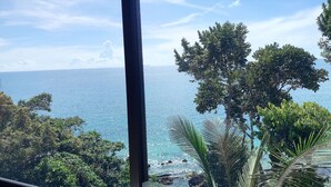 A view of the ocean from a window with trees in the foreground. - Cliff Lanta Suite (Ko Lanta)