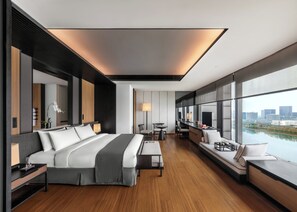 A modern hotel room with a large bed, a sitting area with a view, and a dining table. - The Lalu Nanjing (Nanjing)