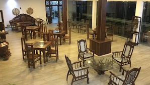 Un'ampia sala da pranzo con arredi in legno e un tavolo centrale in vetro.