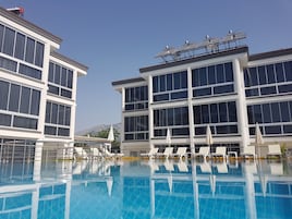 Una piscina al aire libre de temporada, sombrillas