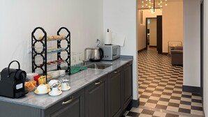 A modern kitchen with a checkered floor, a coffee machine, and a microwave on the counter. - Santa Monica Townhouse (Rome)