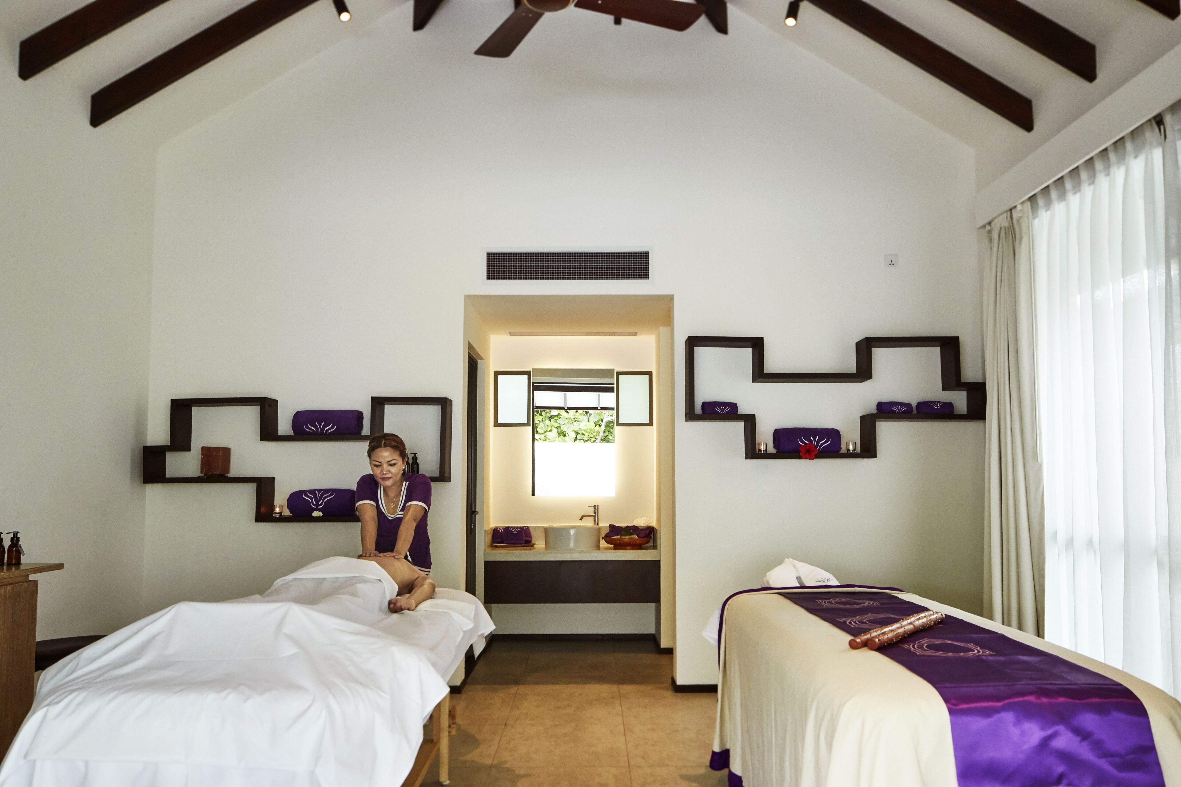 Une chambre d’hôtel avec deux lits, une salle de bain et un miroir.