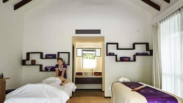 Une chambre d’hôtel avec deux lits, une salle de bain et un miroir.