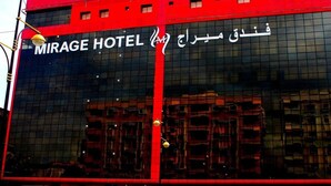 Un edificio moderno con fachada roja y un gran ventanal que muestra el texto 