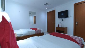 Habitación de hotel con dos camas, un televisor, un espejo y un armario.