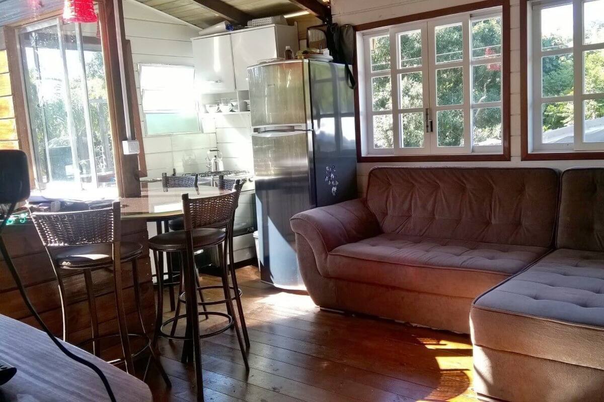 Un salon confortable avec un canapé, une table à manger et des chaises, et une cuisine en arrière-plan.