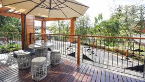 A wooden deck with a pergola, outdoor seating, and a view of the street. - Hotel Refúgio da Montanha - 900m da Rua Coberta (Gramado)