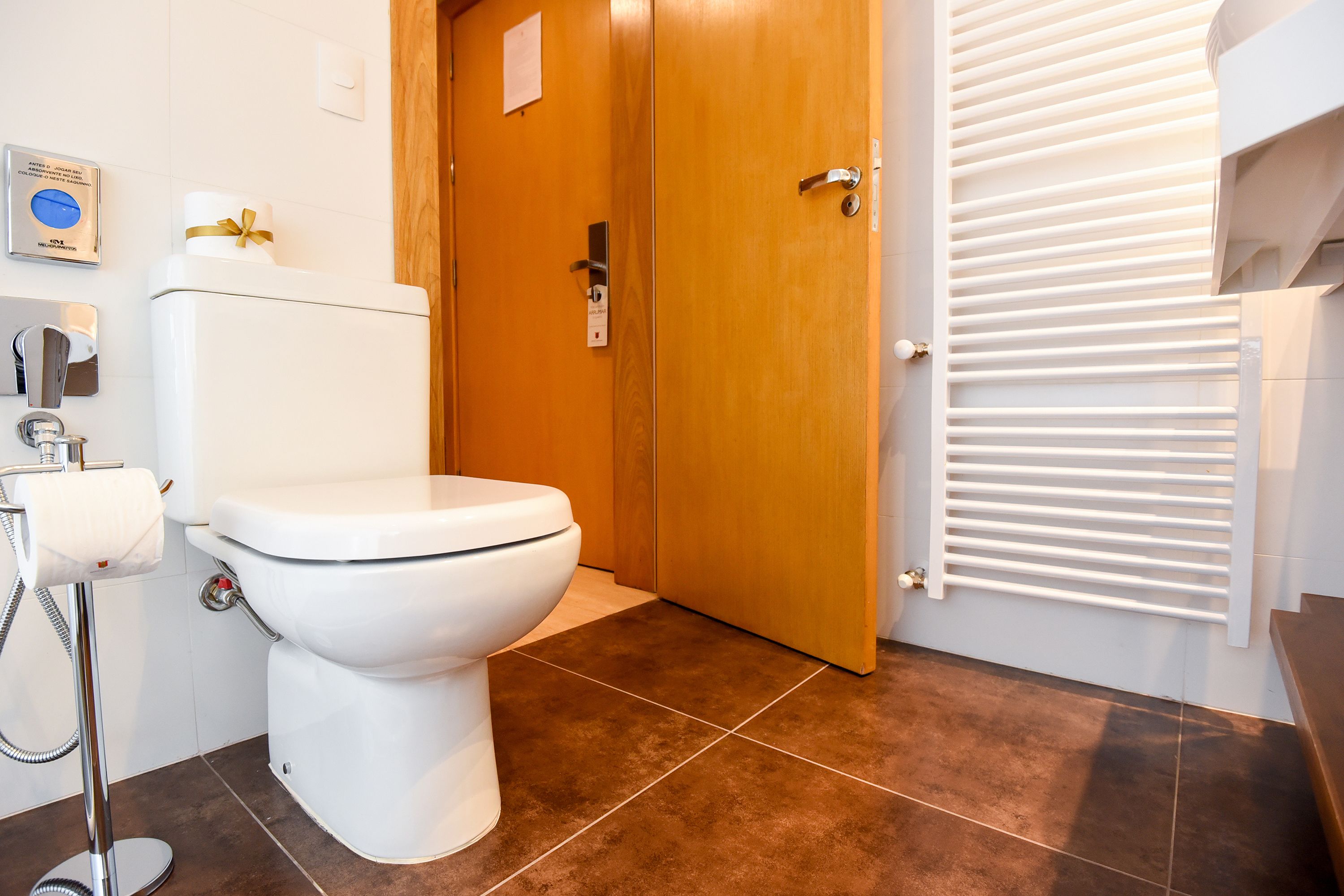 Une salle de bain équipée de toilettes, d’un distributeur de serviettes et d’un espace douche.
