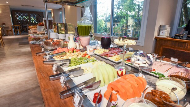 A buffet with various food items and beverages, including fruits, cheeses, and a green smoothie. - Hotel Refúgio da Montanha - 900m da Rua Coberta (Gramado)