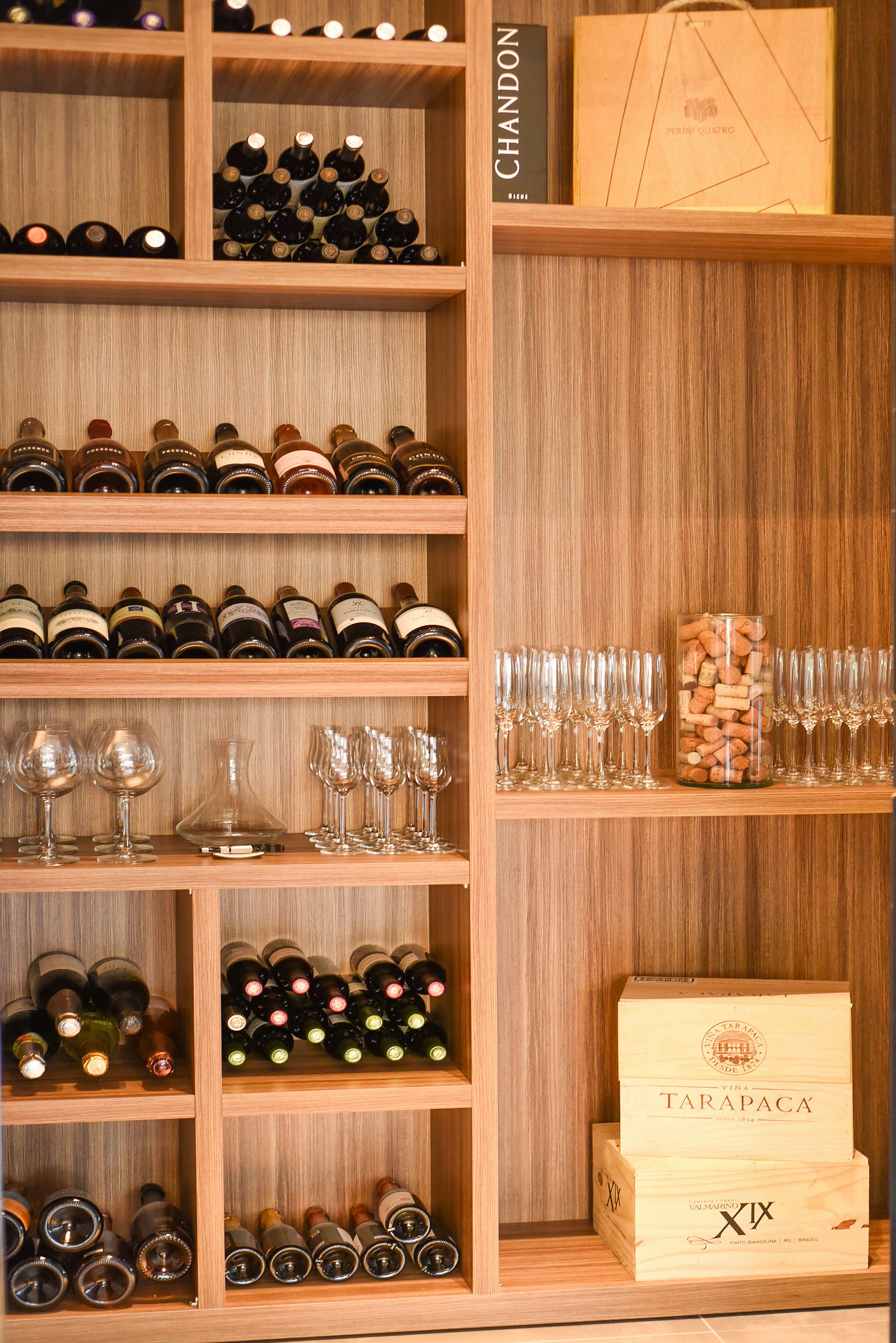 A wine cellar with multiple shelves of wine bottles and glasses.