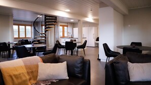 Un interior moderno con una escalera espiral, comedor y cocina.