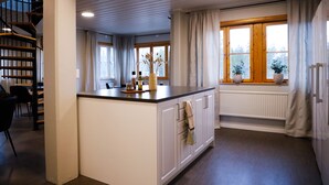 Una cocina moderna con una isla central, armarios de madera y una ventana con cortinas.