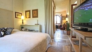 Una camera d'albergo con un letto, una televisione, una scrivania e vista su un campo sportivo.