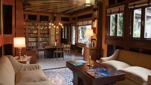 Una biblioteca accogliente con scaffali, un tavolo da pranzo e posti a sedere comodi.