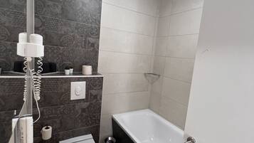 A modern bathroom with a white sink, a bathtub, and a shower.