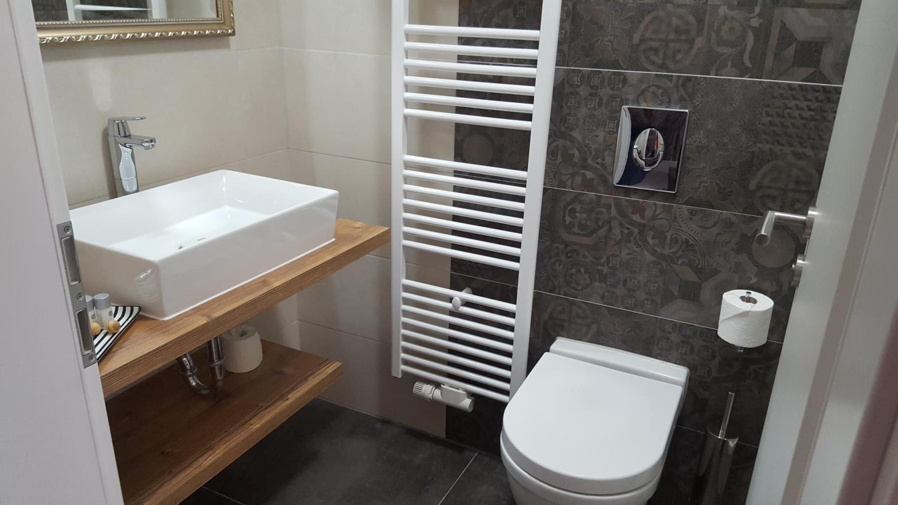 A bathroom with a white sink, a toilet, a towel rack, and a mirror.