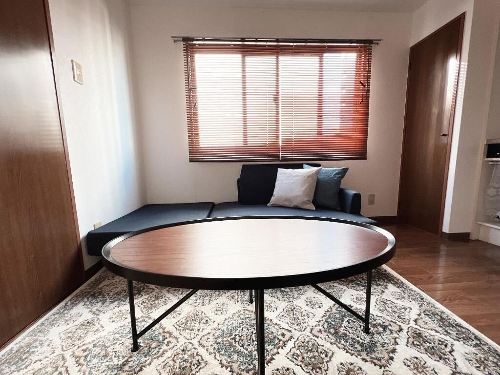Une pièce avec une table ronde, un canapé et un tapis à motifs.