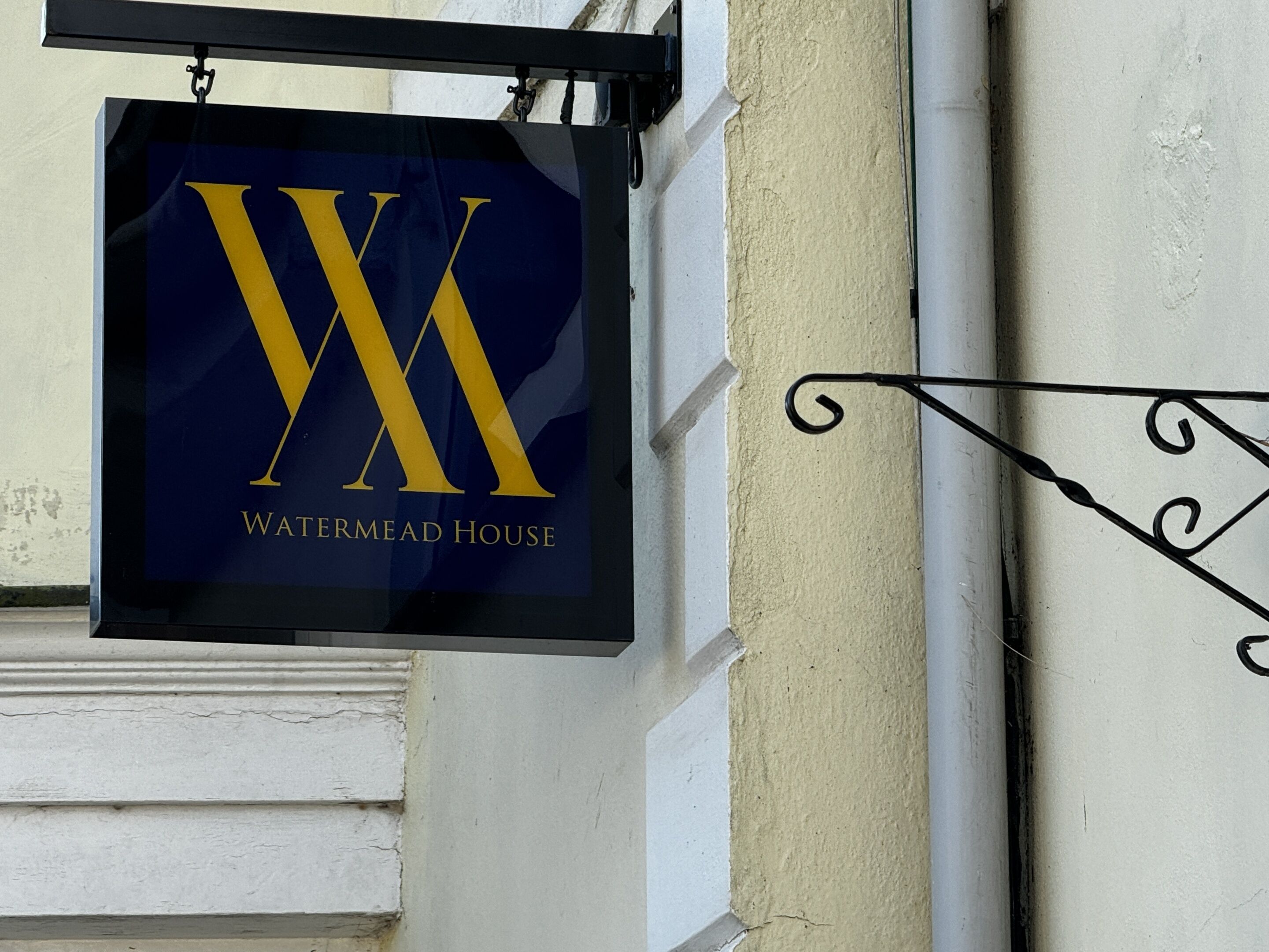 A sign with a large 'W' and 'WATERMEAD HOUSE' text, indicating a hotel or property name.