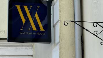 A sign with a large 'W' and 'WATERMEAD HOUSE' text, indicating a hotel or property name.