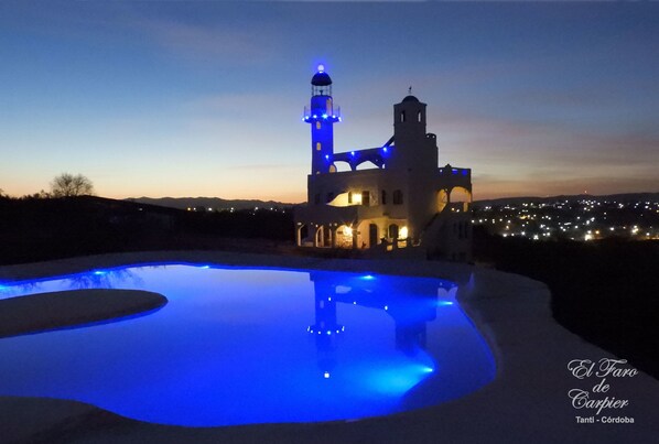 Una piscina al aire libre, sillones reclinables de piscina