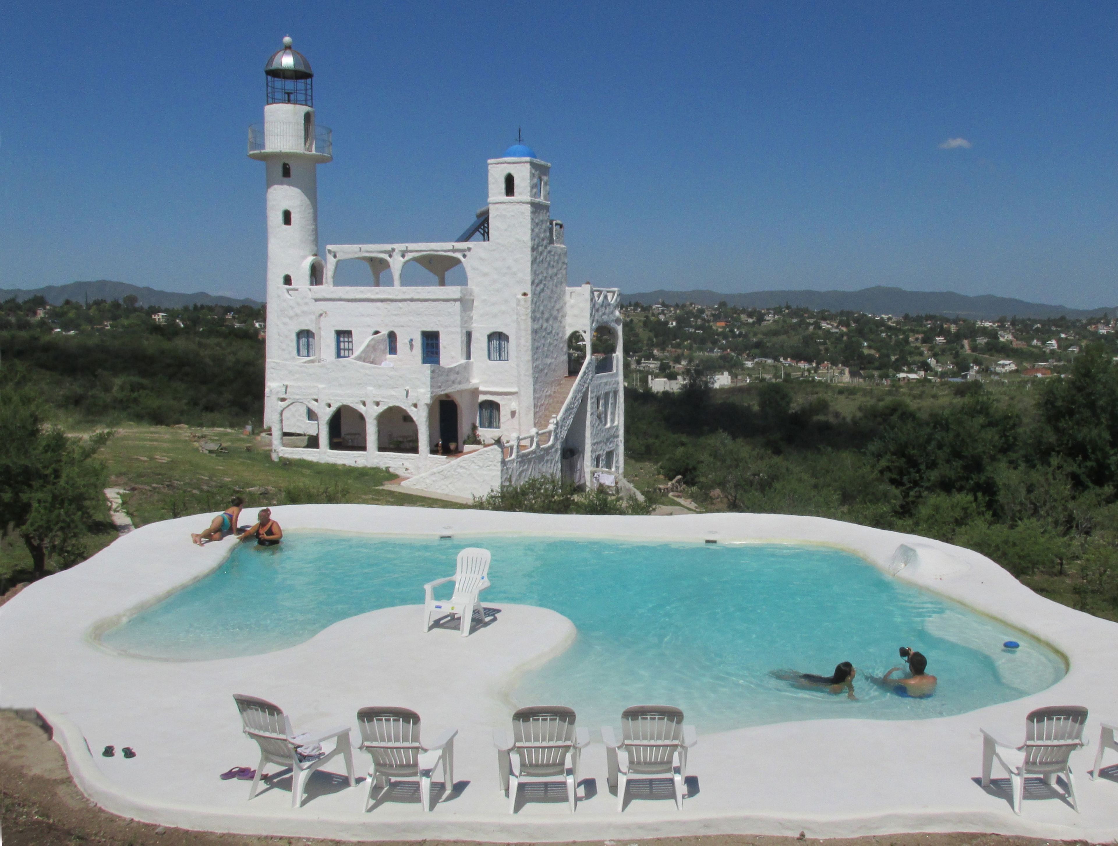 Una piscina al aire libre, sillones reclinables de piscina
