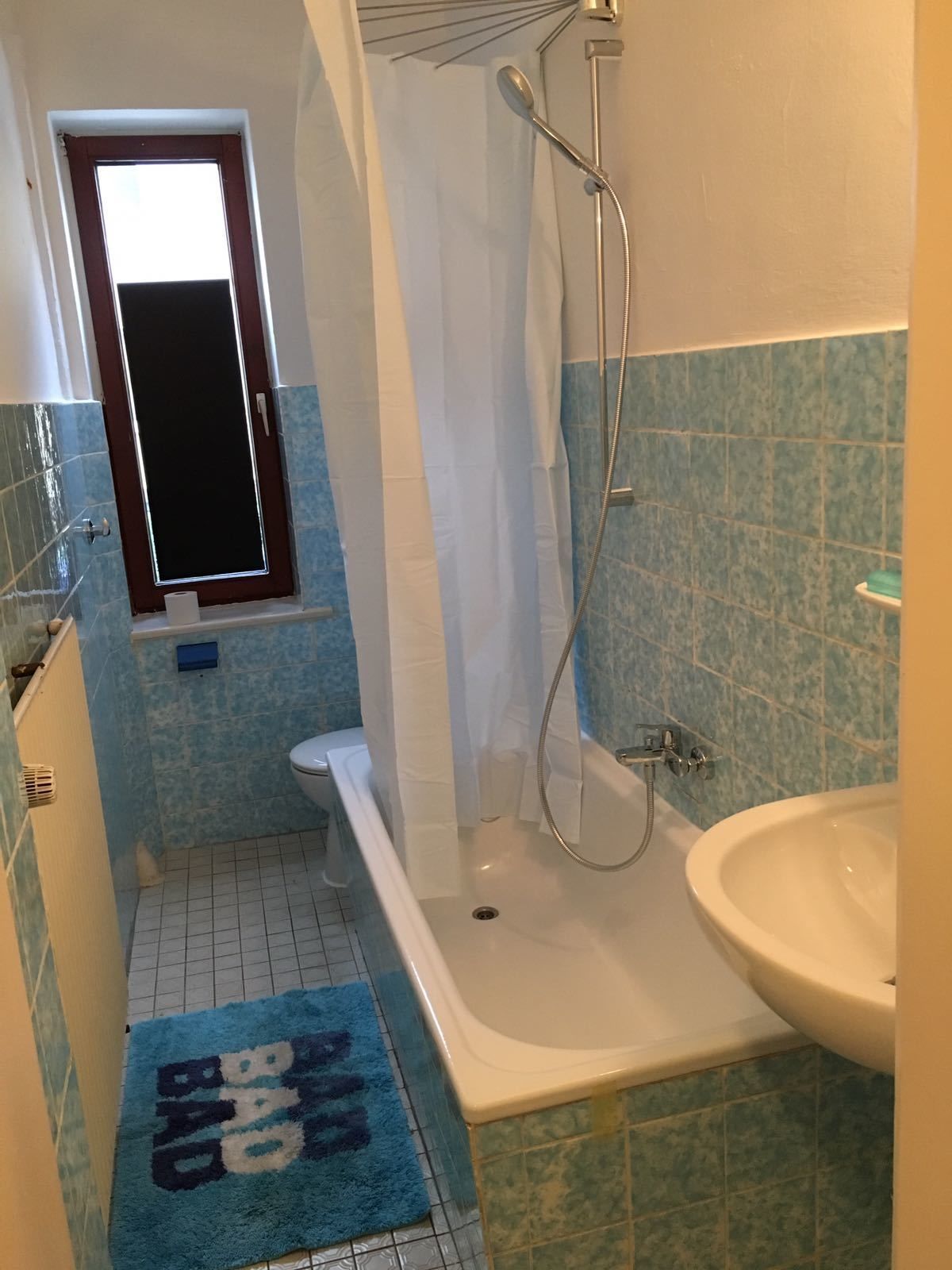 Une salle de bain avec une baignoire, une douche et un lavabo.